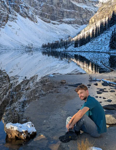 Thomas Bood sitting at the edge of a lake